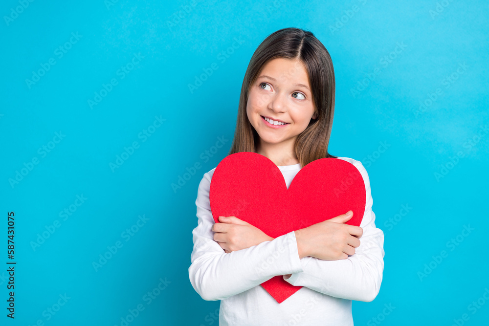 Photo of friendly schoolgirl with straight hairdo dressed white shirt hug red heart look empty space isolated on blue color background Photo of friendly schoolgirl with straight hairdo dressed white shirt hug red heart look empty space isolated on blue color background