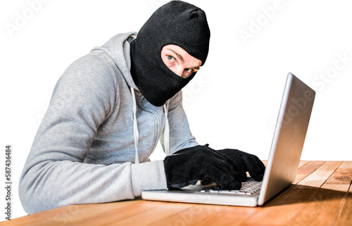 Fotografie Focused thief with hood typing on laptop