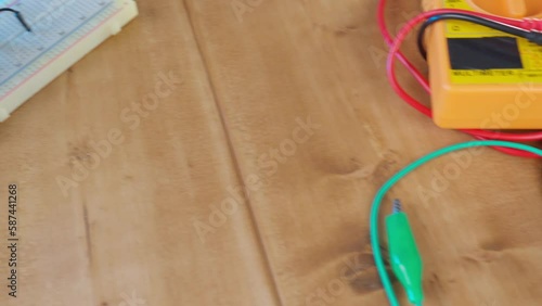 Breadboard with electrical elements, on a wooden table. photo