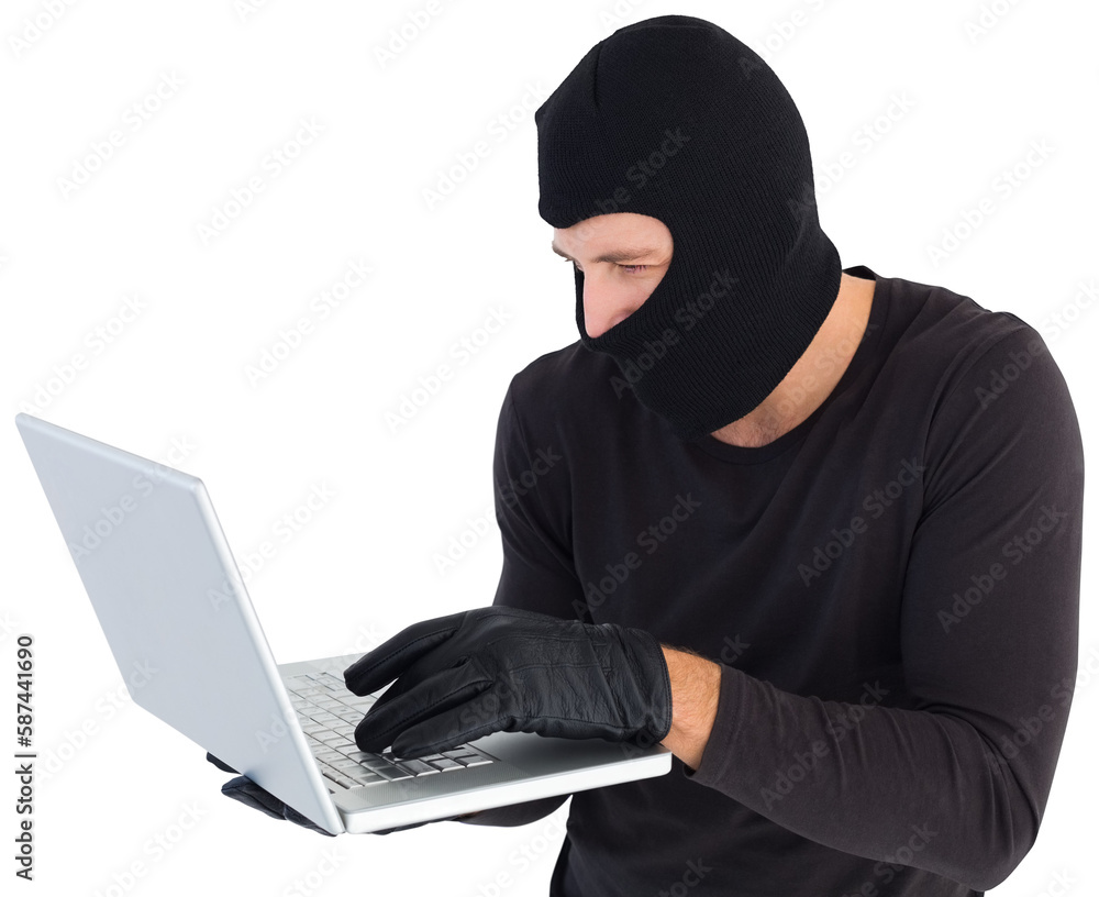 Focused burglar standing holding laptop Focused burglar standing holding laptop