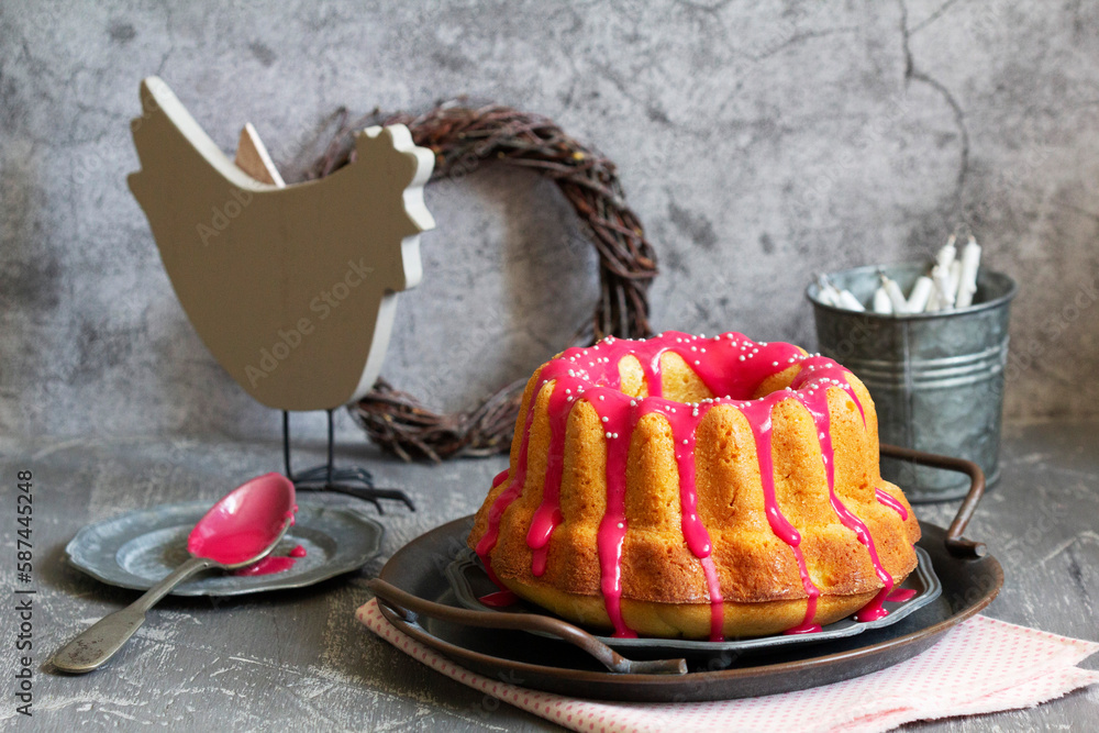 Orange vanilla cake covered with pink icing, Easter decor.