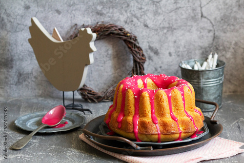 Obraz na płótnie Orange vanilla cake covered with pink icing, Easter decor. w salonie