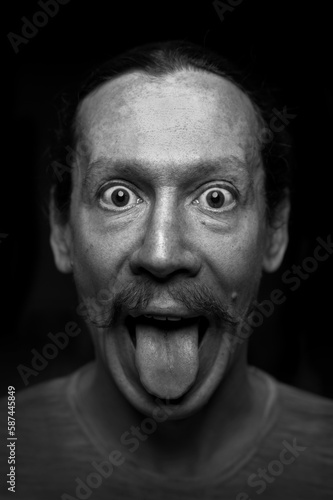 man shows tongue, black and white emotional photo