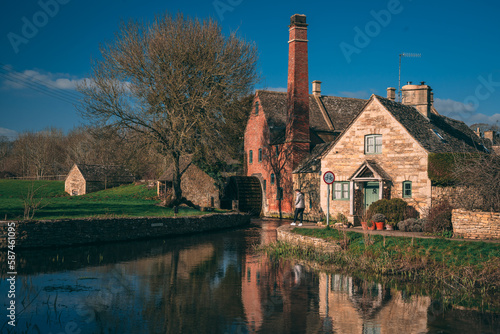 Iconic medieval built houses next to River Eye in Lower Slaughter in Cotswolds England