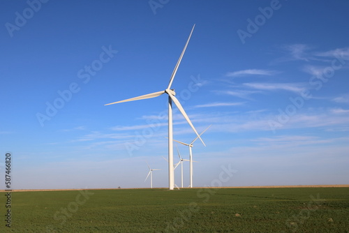 Giant wind turbine in a field over green agriculture
