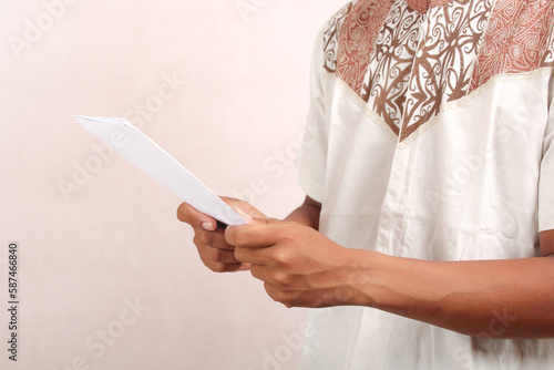 closeup, muslim man holding white envelope or bill looking isolated on white.