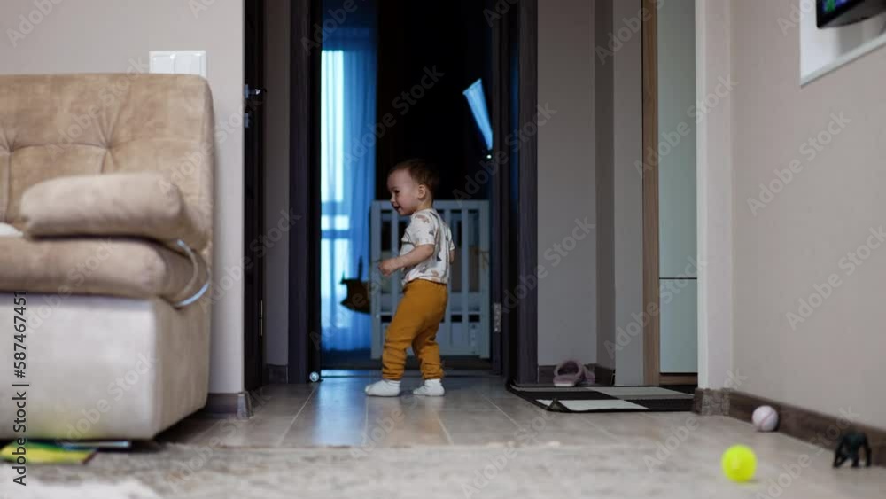 Joyful baby boy runs from room to room. Happy kid smiling and playing in his home. Joyful baby boy runs from room to room. Happy kid smiling and playing in his home.