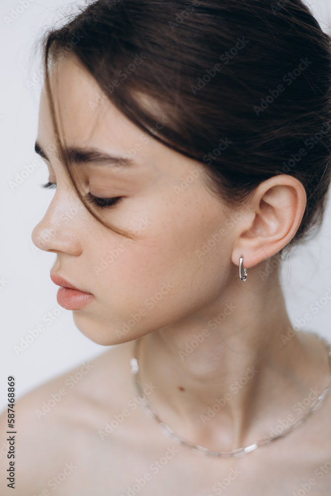 stylish portrait of a young 15-year-old model girl with natural light in a spacious photo studio