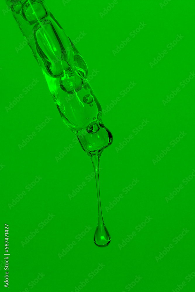 Cosmetic pipette with dripping liquid, oil and drops on a green background, serum, serum, gel, vitamin, water, oil. Natural cosmetic Cosmetic pipette with dripping liquid, oil and drops on a green background, serum, serum, gel, vitamin, water, oil. Natural cosmetic