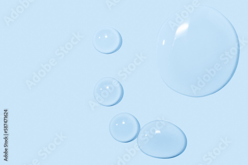 large drops of transparent Gel liquid, water on a blue background, top view, close-up