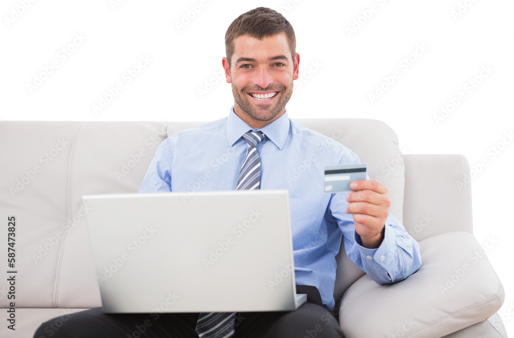 Smiling businessman with credit card and laptop sitting on sofa Smiling businessman with credit card and laptop sitting on sofa