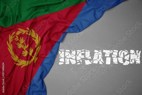 waving colorful national flag of eritrea on a gray background with broken text inflation. 3d illustration