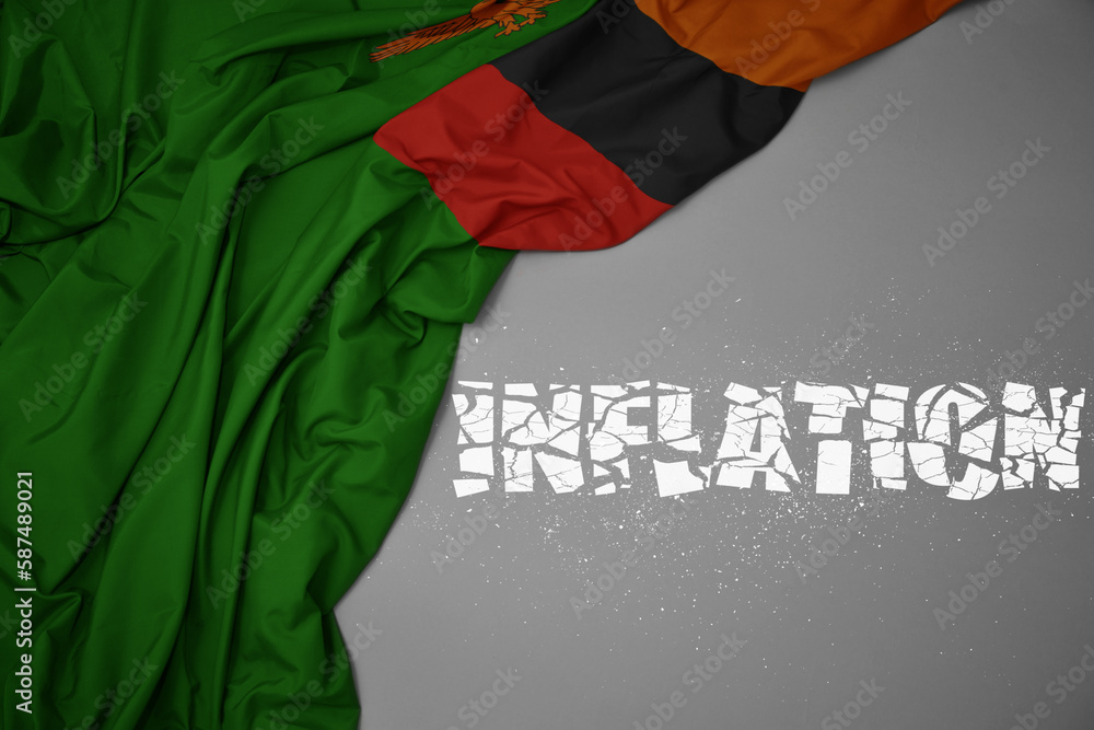 waving colorful national flag of zambia on a gray background with broken text inflation. 3d illustration