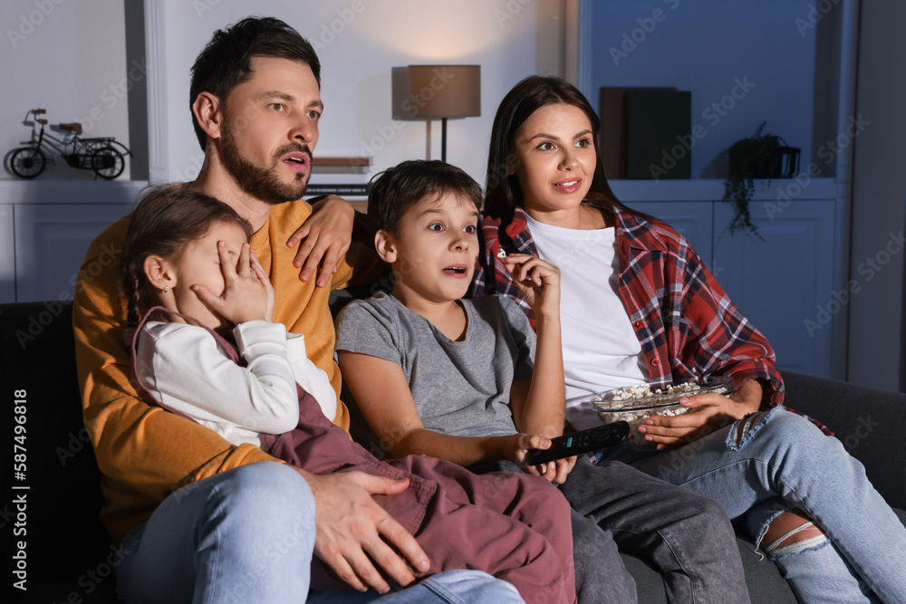 Emotional family watching TV at home in evening Emotional family watching TV at home in evening