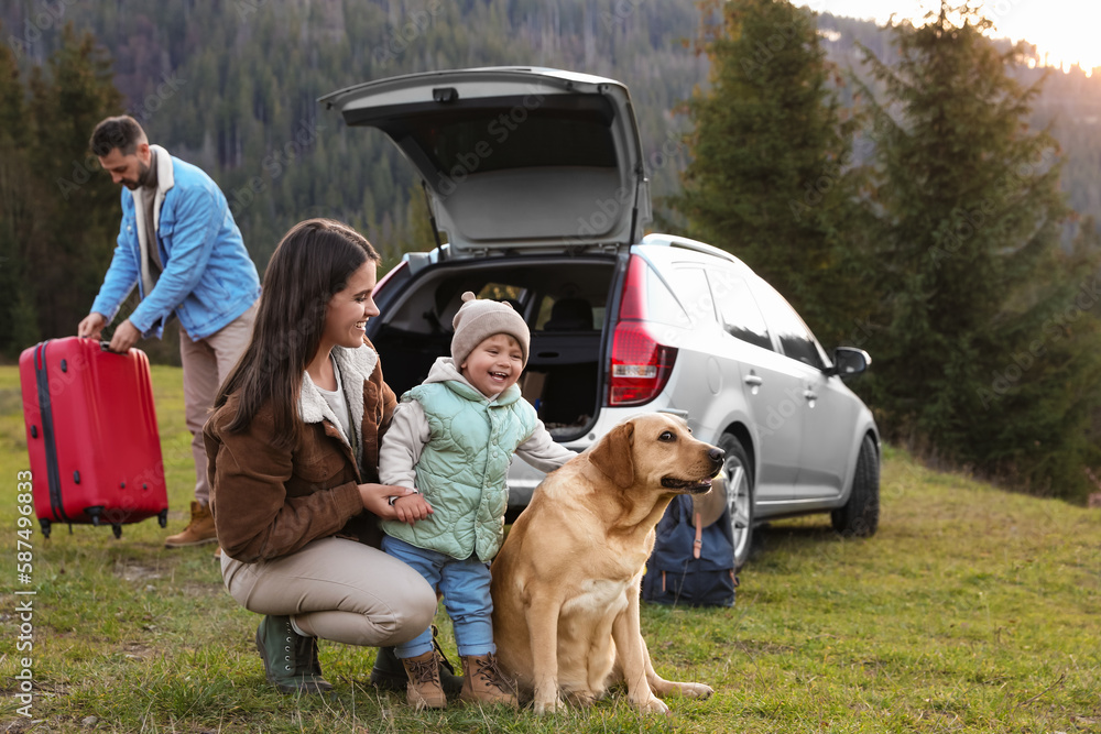 Mother with her daughter, dog and man near car in mountains. Family traveling with pet Mother with her daughter, dog and man near car in mountains. Family traveling with pet