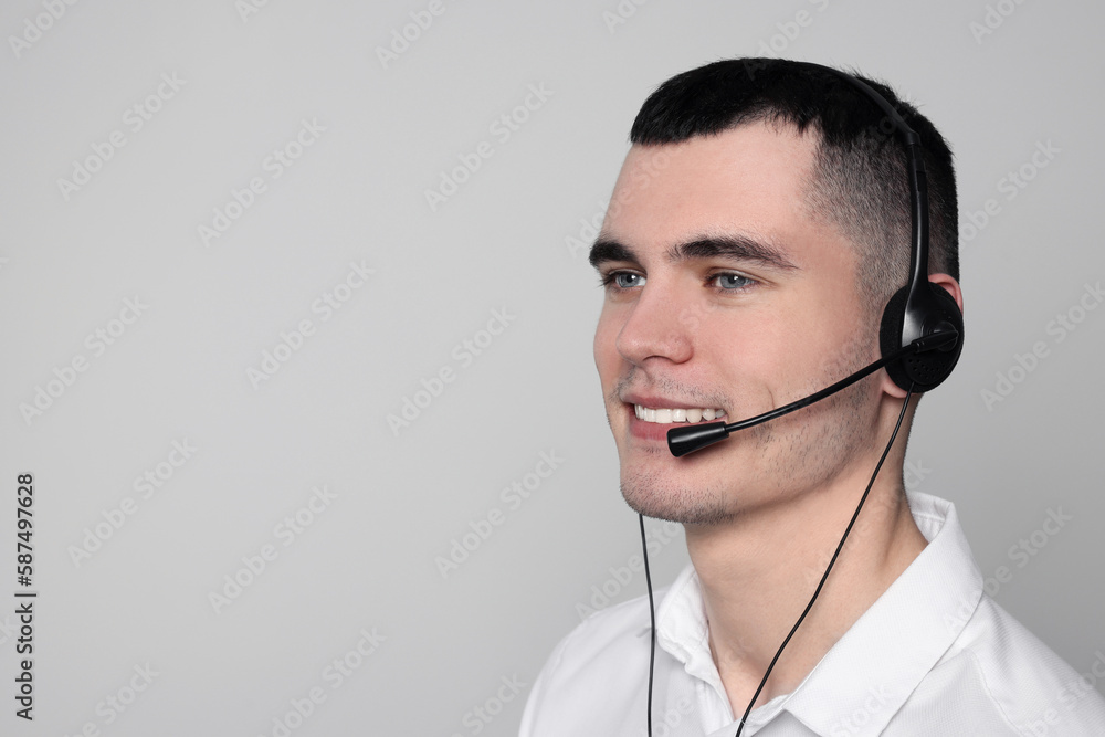Hotline operator with headset on light grey background, space for text Hotline operator with headset on light grey background, space for text