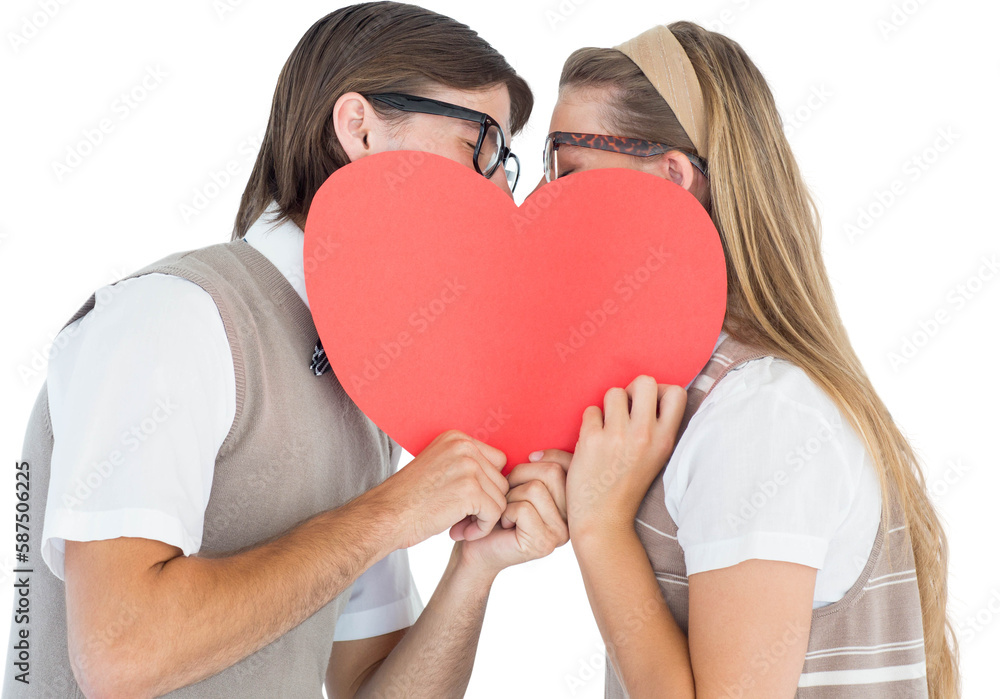 Geeky hipsters kissing behind heart card Geeky hipsters kissing behind heart card
