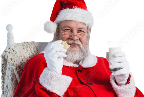 Santa Claus holding glass of milk and cookie