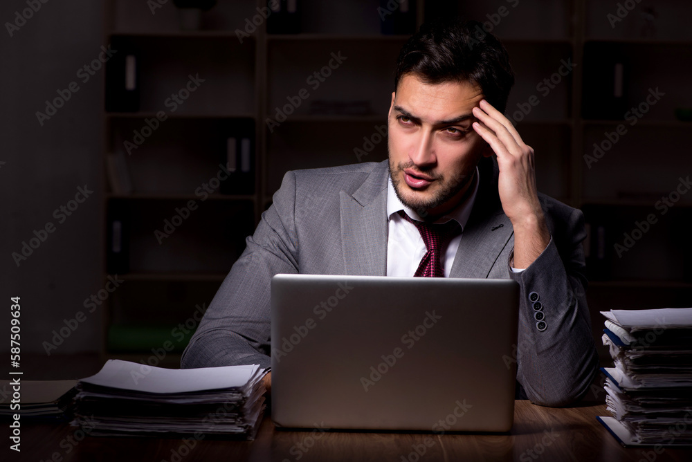 Young male employee working late in the office Young male employee working late in the office
