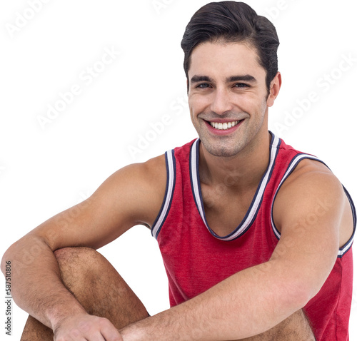 Portrait of happy athlete sitting on white background