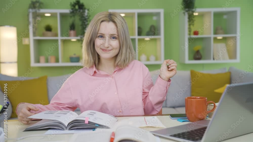 University student girl who loves to read.
University student girl doing homework at home is happy and loves studying. Makes positive gesture looking at camera.
University student girl who loves to read.
University student girl doing homework at home is happy and loves studying. Makes positive gesture looking at camera.