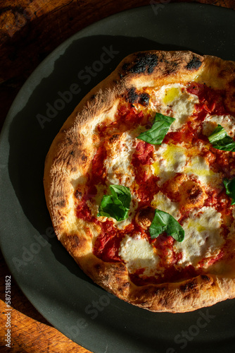 Photos photo of a neapolitan style pizza on a plate on a wooden table