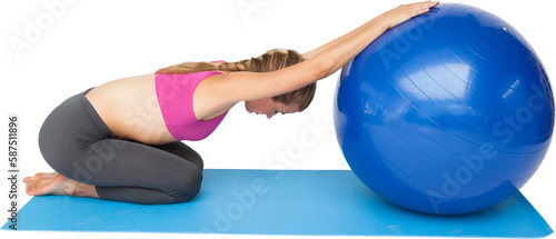 Side view of a fit young woman exercising with fitness ball