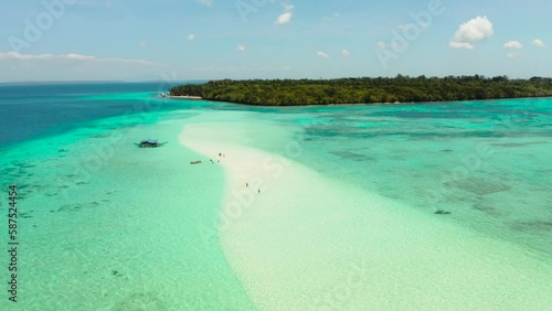 Sandy beach with tourists among turquoise waters and coral reefs. Mansalangan sandbar. Beach at the atoll. Summer and travel vacation concept. Balabac, Palawan, Philippines. photo