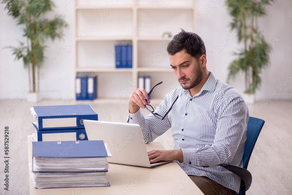 Young male employee working in the office Young male employee working in the office