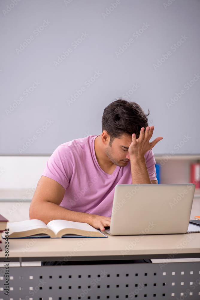 Young male student preparing for exams in the classroom Young male student preparing for exams in the classroom