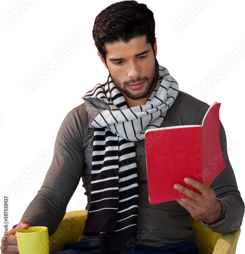 Young man reading book while having coffee on seat
