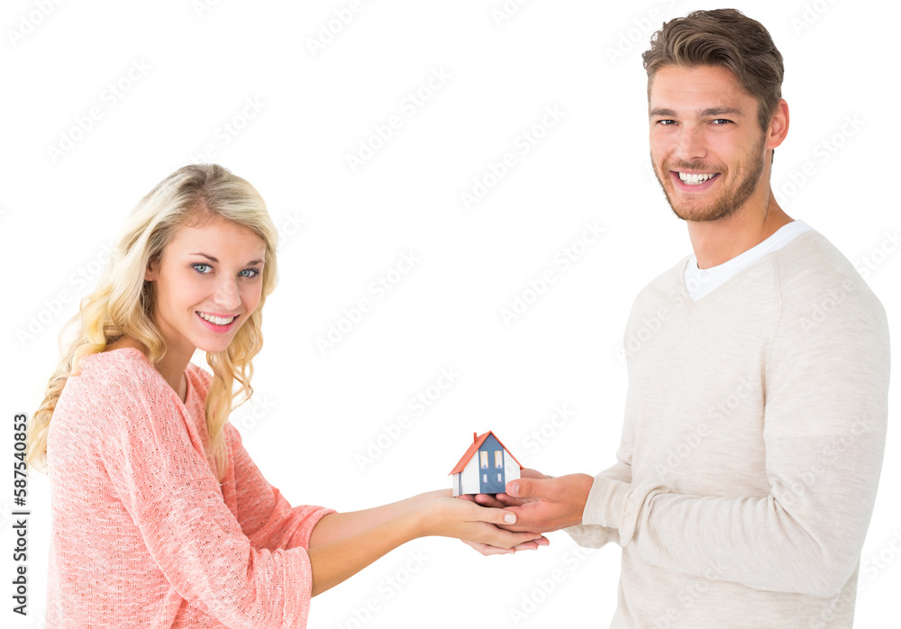 Attractive couple holding miniature house model