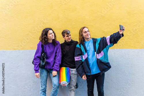 Young diverse friends taking selfies with a mobile phone outdoors.