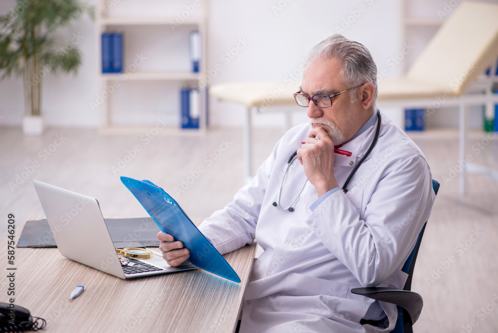 Old male doctor working in the clinic Old male doctor working in the clinic
