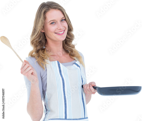 Smiling woman holding frying pan and wooden spoon 