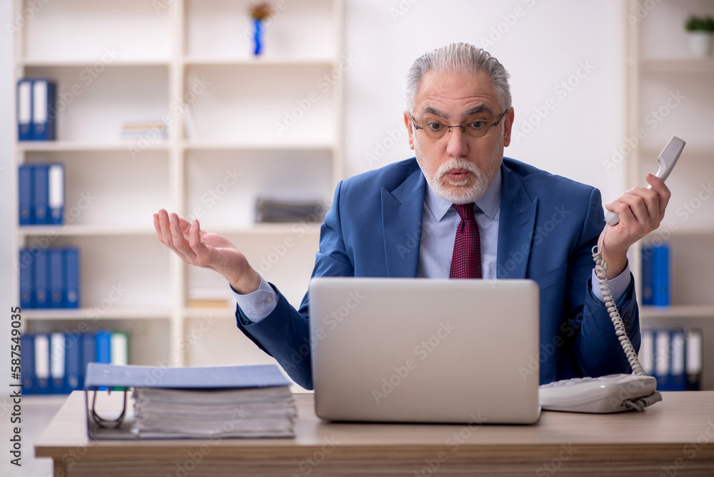 Old male employee and too much work at workplace Old male employee and too much work at workplace