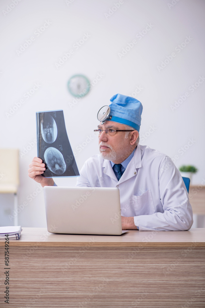 Old male docror otolaryngologist working in the clinic Old male docror otolaryngologist working in the clinic