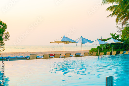 Umbrella and chair around swimming pool with sea ocean view