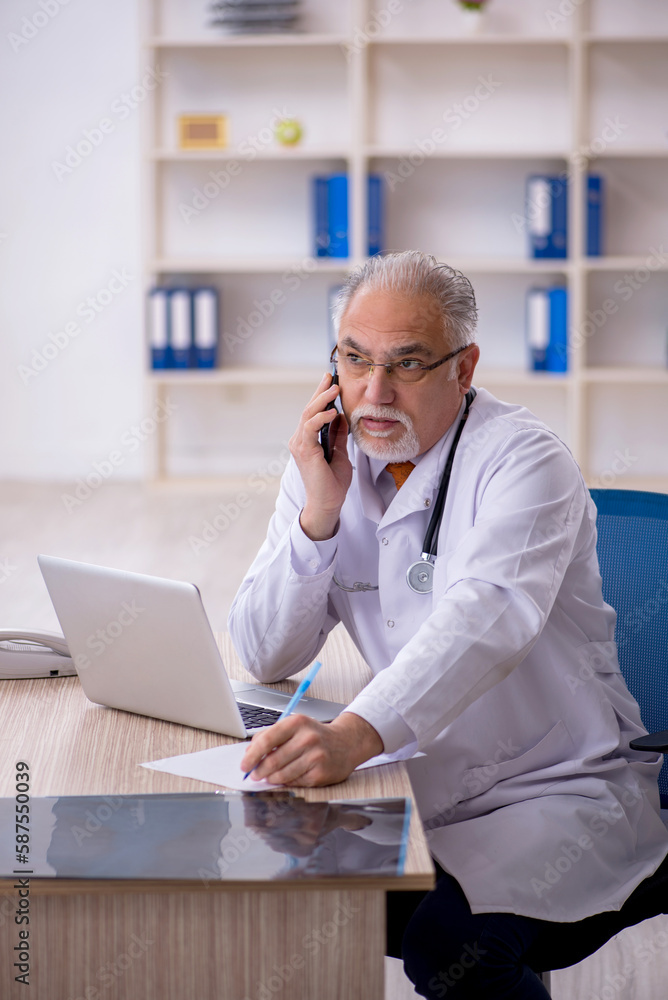 Old male doctor in telemedicine concept Old male doctor in telemedicine concept