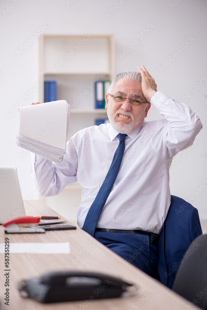 Old male employee working in the office Old male employee working in the office