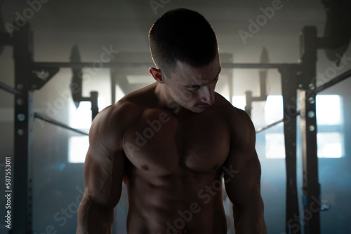 Cropped portrait view of a muscular young man with perfect six pack abs. Man posing on camera