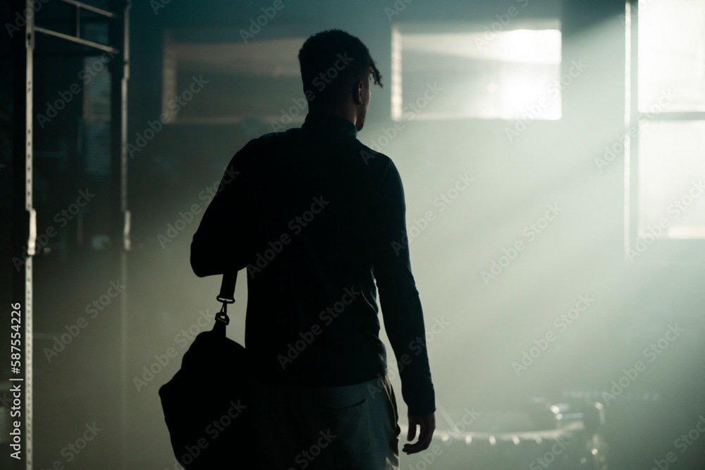 Medium view of an athlete walking into the gym with a bag, ready to start training