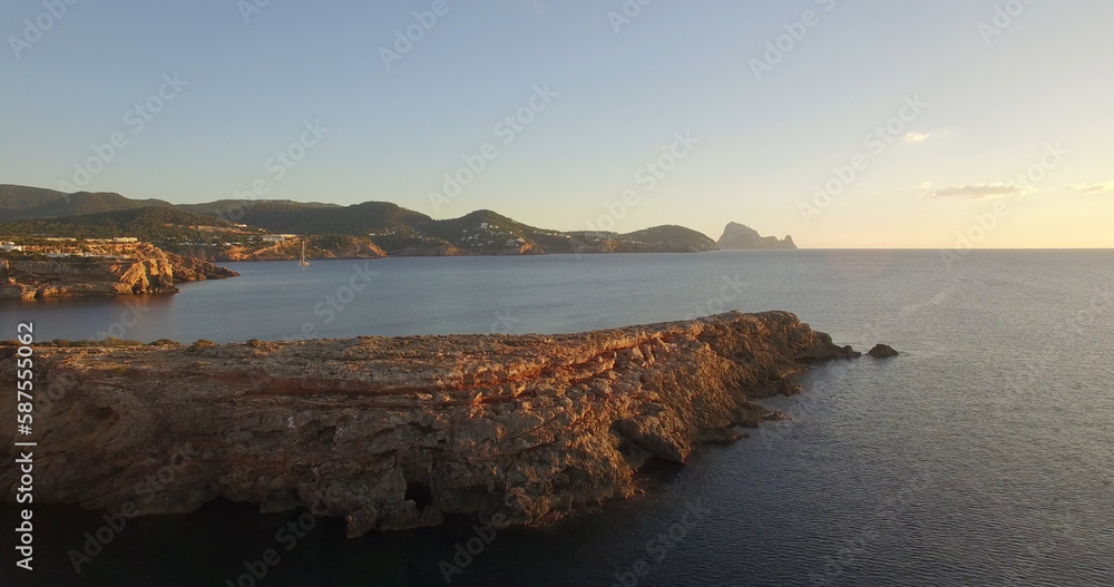 Rock formations by sea during sunset