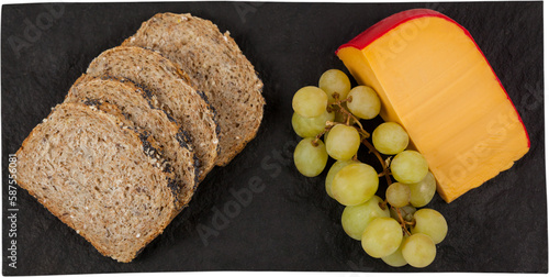 Gouda cheese, grapes and brown bread slices on slate