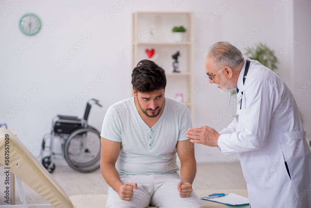 Fototapeta premium Young male patient visiting old male doctor