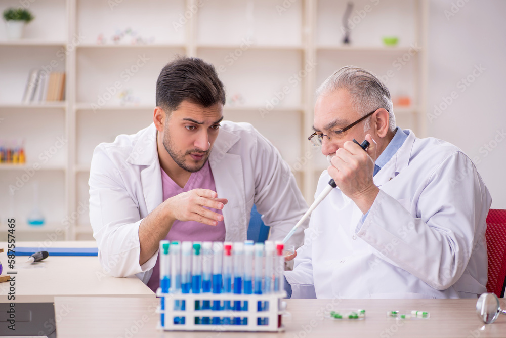 Two male chemists working at the lab Two male chemists working at the lab