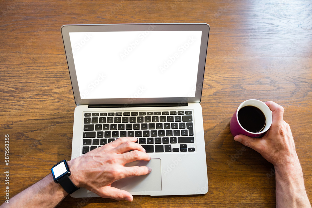 Man using laptop and holding coffee cup Man using laptop and holding coffee cup