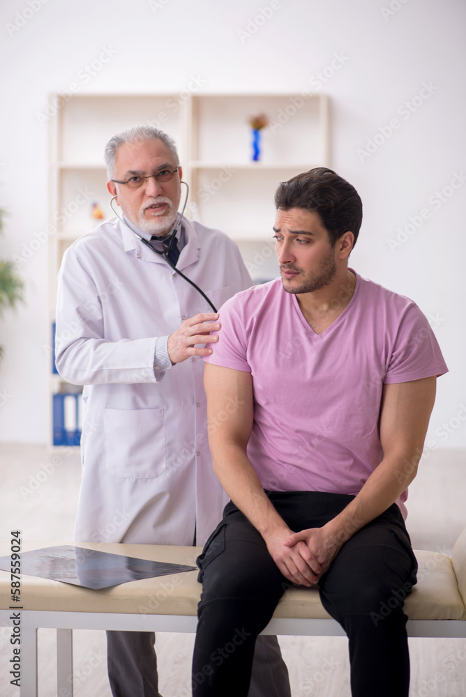 Fototapeta premium Young male patient visiting old male doctor