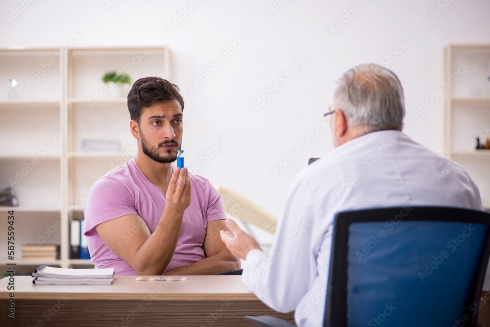 Obraz premium Young male patient visiting old male doctor