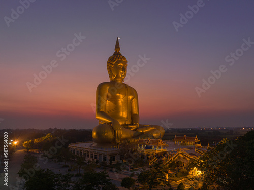 aerial view The moon was above the head of the biggest golden Buddha in the world..scenery red sky in twilight background. .golden big buddha is a popular landmark at wat Muang Ang Thong Thailand. © Narong Niemhom